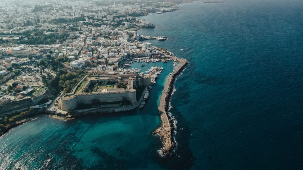 A stunning aerial shot showcasing a coastal city with a prominent fort and marina.